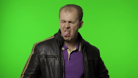 Aggressive-rocker-man-in-brown-leather-jacket-showing-tongue-and-looking-with-crazy-expression
