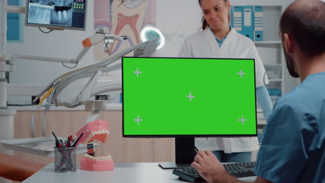 Man-nurse-looking-at-horizontal-green-screen-on-monitor
