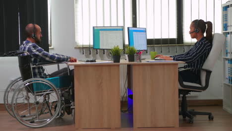 Man-in-wheelchair-using-headset-making-telemarketing