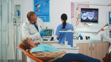 Zahnarzt-Zeigt-Auf-Tablet-Röntgenzähnen