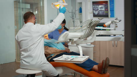 Dentist-treating-teeth-to-senior-woman-patient-in-clinic