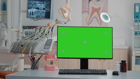 Monitor-Mit-Grünem-Bildschirm-Auf-Dem-Schreibtisch-In-Einer-Leeren-Zahnarztpraxis