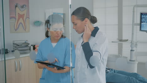 Dentist-and-assistant-analyzing-modern-tablet-screen