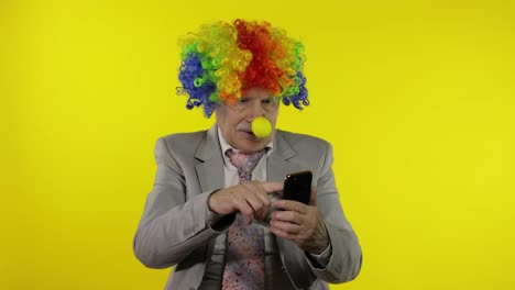 Senior-clown-businessman-entrepreneur-loses-money-while-working-on-phone-online