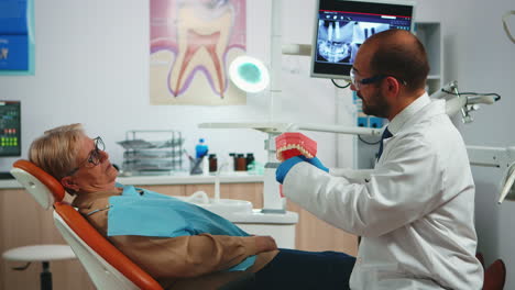 Arzt-Erklärt-Anhand-Eines-Modells-Eines-Zahnskeletts