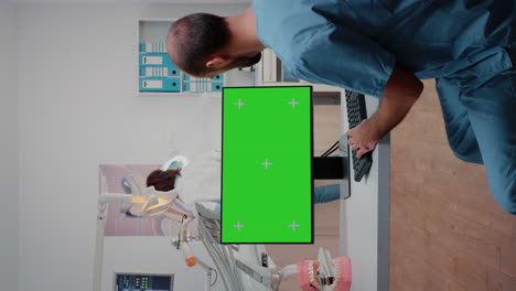 Vertical-video:-Assistant-using-horizontal-green-screen-on-computer