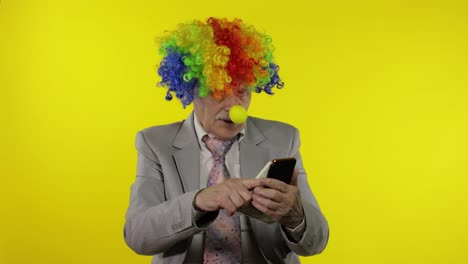 Clown-businessman-freelancer-loses-money-while-playing-on-phone-online-games