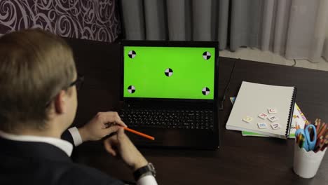 Man-teacher-making-online-video-call-on-laptop.-Green-screen.-Distance-education