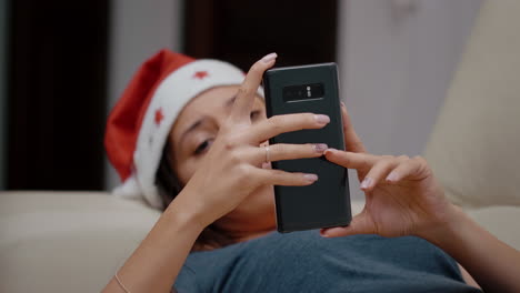 Close-up-of-festive-woman-looking-at-smartphone-and-TV