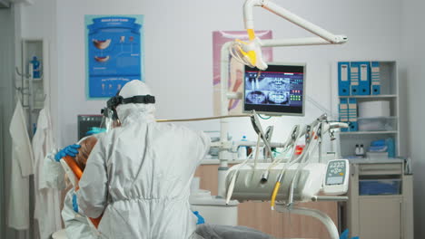 Dentist-with-face-shield-working-in-dental-unit-during-covid-19