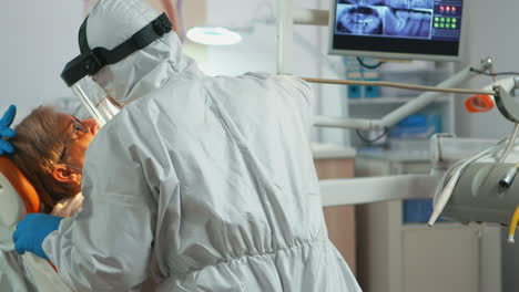 Close-up-of-dentistry-doctor-in-coverall-using-drilling-machine