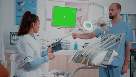 Dentist-receiving-teeth-scan-from-man-while-looking-at-green-screen