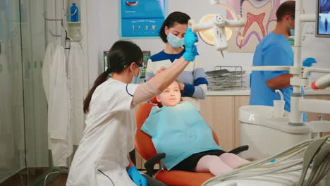 Técnico-Dentista-Examinando-Al-Pequeño-Paciente.