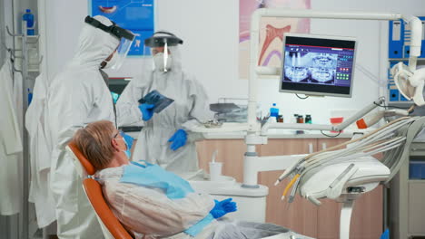 Estomatólogo-En-Traje-Protector-Explicando-La-Radiografía-Dental