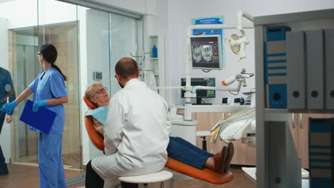 Especialista-Dental-Hablando-Con-Un-Paciente-Mayor