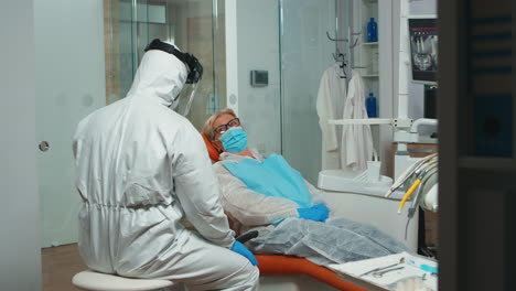 Médico-En-Mono-Mostrando-Al-Paciente-Una-Radiografía-En-Un-Monitor-Estomatológico
