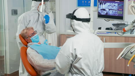 Doctor-in-coverall-showing-dental-hygiene-using-mock-up-of-skeleton