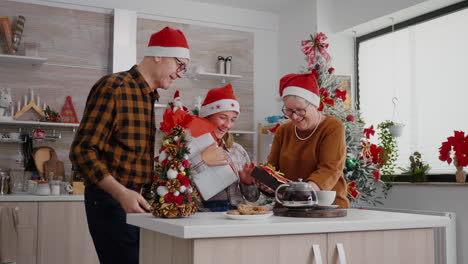 Großeltern-Geben-Wrapper-Weihnachtsgeschenk-Mit-Schleife-Darauf-An-Enkelin