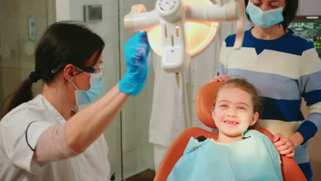 Zahnärztin-Zündet-Lampe-An,-Um-Kleine-Patientin-Zu-Untersuchen