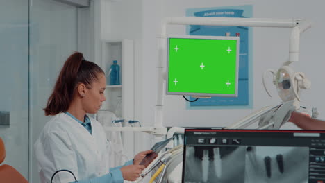 Frau-Arbeitet-Als-Zahnärztin-Mit-Grünem-Bildschirm-Und-Röntgenscan