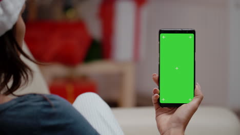 Close-up-of-woman-vertically-holding-green-screen-on-smartphone