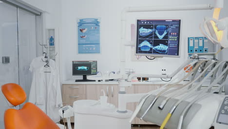 Revealing-shot-of-orthodontist-chair-with-nobody-in,-tooth-x-ray-images-on-display