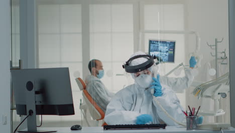 Stomatology-assistant-with-ppe-suit-using-computer