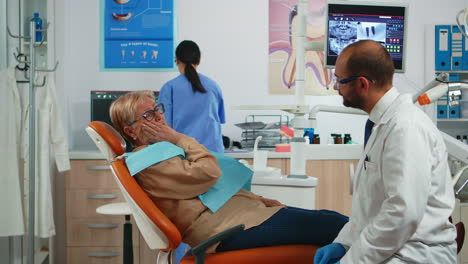 Alter-Patient-Berührt-Wange-Und-Zeigt-Zahn-Mit-Schmerzen