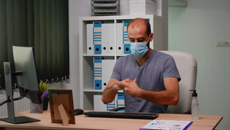 Entrepreneur-with-mask-typing-on-computer