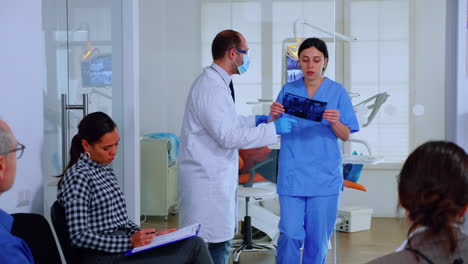 Dentista-Mostrando-Dientes-Radiografía-Revisándolo-Con-Nusre