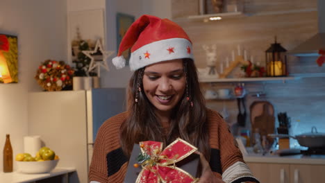Festive-woman-with-santa-hat-receiving-gift