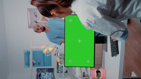 Vertical-video:-Dentist-working-with-horizontal-green-screen