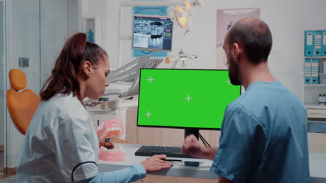 Dentist-and-nurse-looking-at-green-screen-on-monitor
