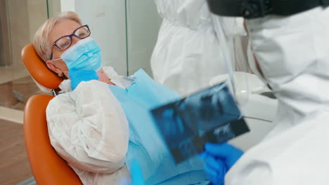 Arzt-Mit-Gesichtsschutz,-Der-Das-Zahnärztliche-Panorama-Röntgenbild-überprüft