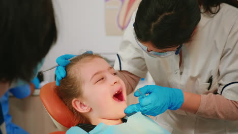 Nahaufnahme-Eines-Kleinen-Patienten,-Der-Während-Der-Zahnärztlichen-Untersuchung-Mit-Offenem-Mund-Auf-Einem-Stuhl-Liegt
