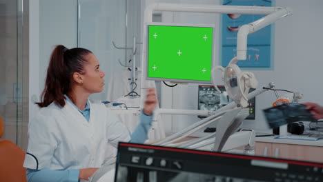 Mujer-Analizando-La-Pantalla-Verde-En-El-Monitor-Y-La-Radiografía-De-Los-Dientes.