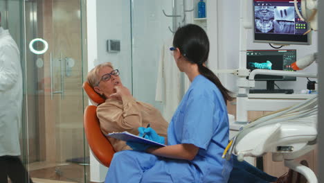 Paciente-Con-Dolor-De-Muelas-Explicando-El-Problema-Dental-A-La-Enfermera.
