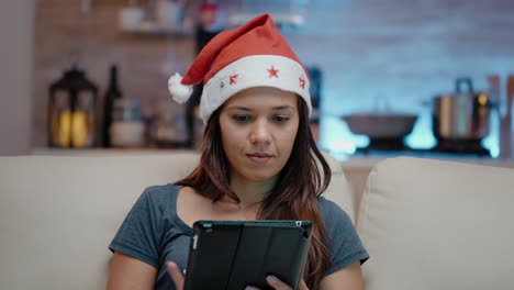 Person-Trägt-Weihnachtsmütze-Und-Arbeitet-An-Einem-Digitalen-Tablet