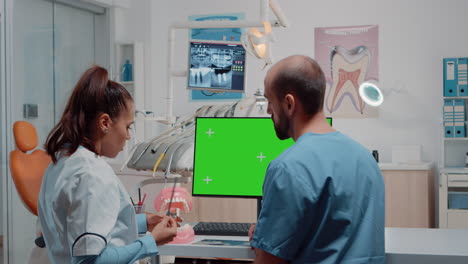 Woman-dentist-and-man-working-with-green-screen-on-monitor