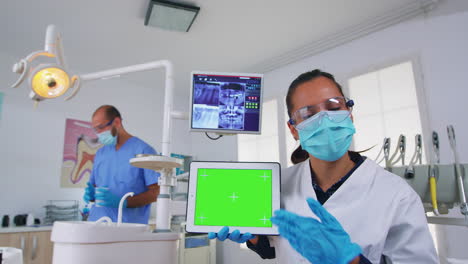 Patientenperspektive-Des-Zahnarztes,-Der-Röntgenaufnahmen-Mit-Einem-Tablet-Mit-Grünem-Bildschirm-Analysiert