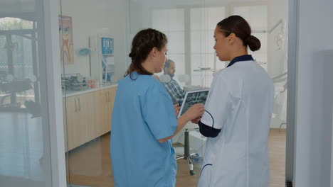 Kieferorthopädie-Team-Bespricht-Zahnpflege-Mit-Röntgenscan