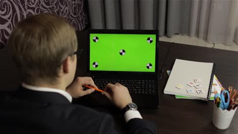 Man-teacher-making-online-video-call-on-laptop.-Green-screen.-Distance-education