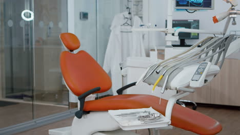 Revealing-shot-of-orthodontist-dentistry-chair-with-nobody-in,-prepared-for-teeth-dental-health.