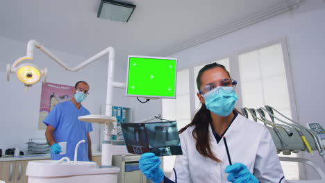 Médico-Dentista-Mostrando-El-Monitor-De-La-Unidad-Con-Pantalla-De-Maqueta,-Paciente-Pov