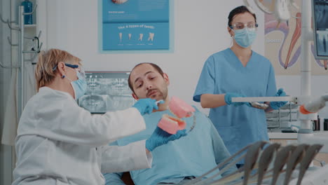 Stomatologe-Verwendet-Künstlichen-Kiefer,-Um-Die-Richtige-Art-Des-Zähneputzens-Zu-Erklären
