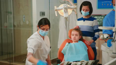 Pediatric-dentist-and-assistant-treating-girl-patient-in-stomatological-clinic