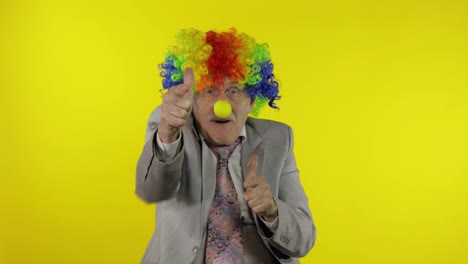 Elderly-clown-businessman-freelancer-boss-making-shot-signs-from-hands