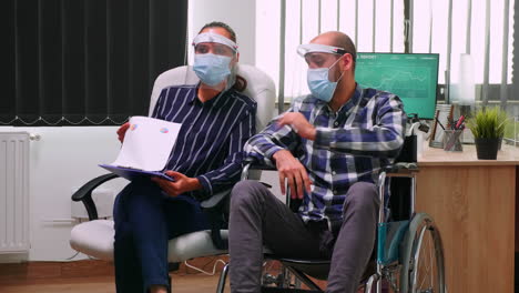 Behinderter-Mann-Und-Partner-Mit-Masken-Bei-Videotreffen