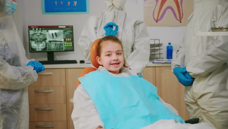 Close-up-of-happy-girl-laughing-at-camera-visiting-dentist-during-global-pandemic