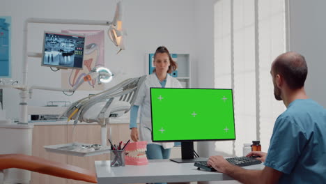 Man-using-monitor-with-horizontal-green-screen